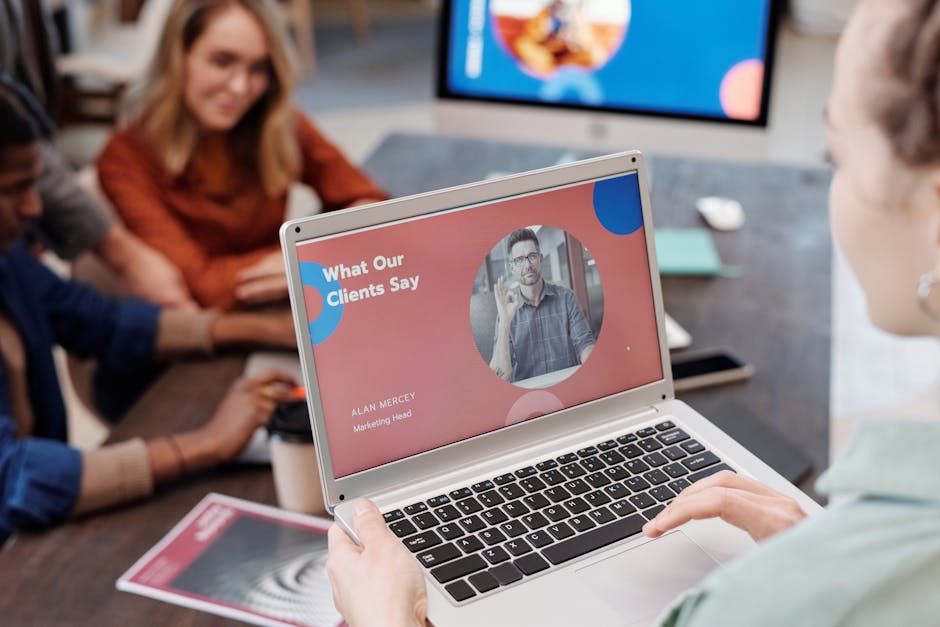 Team discussing project with a laptop presentation in a modern office setting.